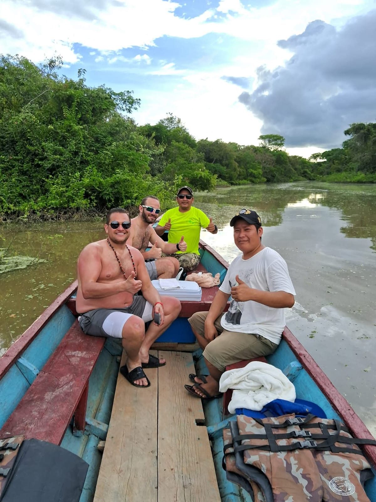 A small group travelling upriver in a wooden boat