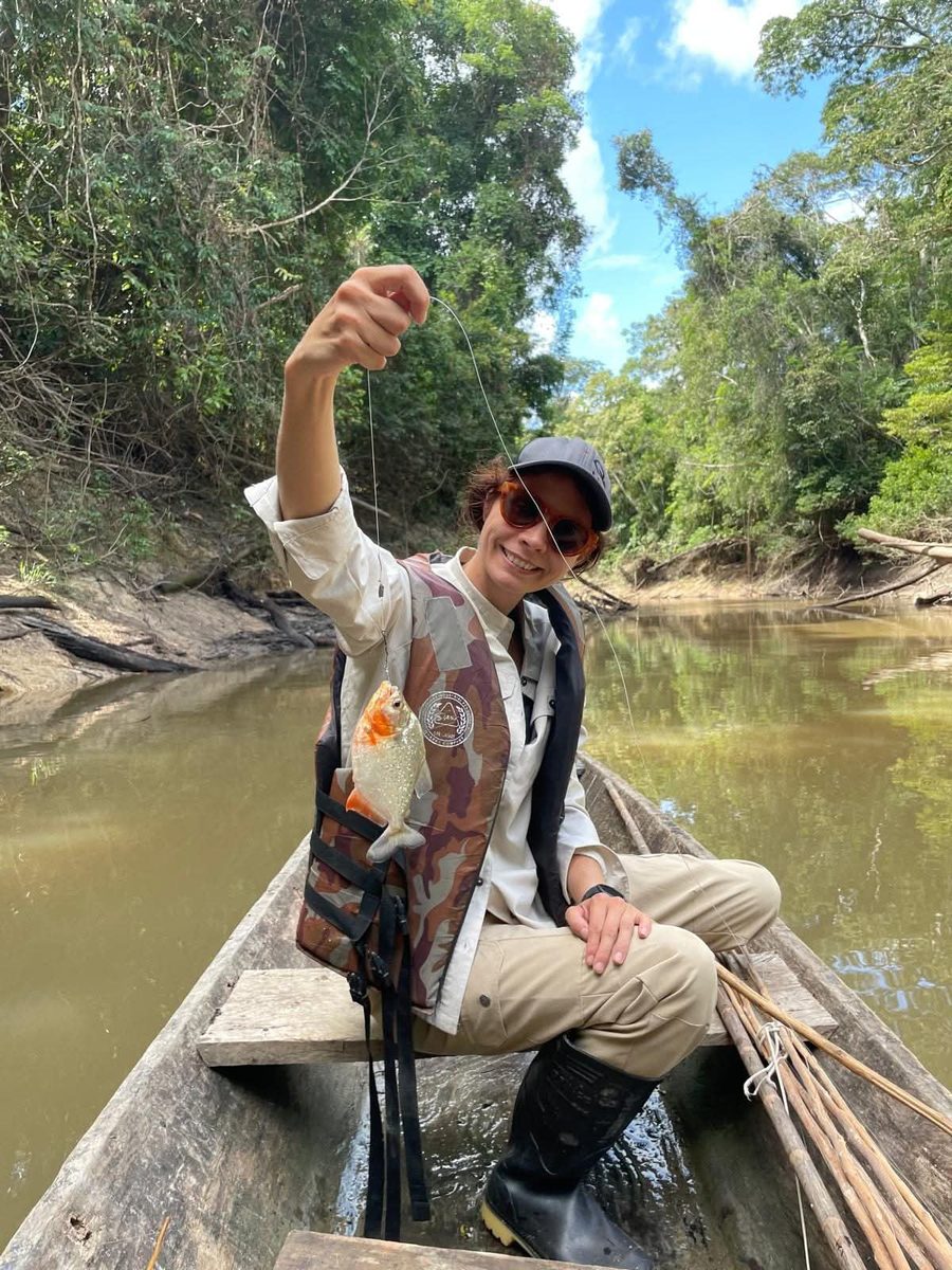 A guest holding a piranha caught from the boat